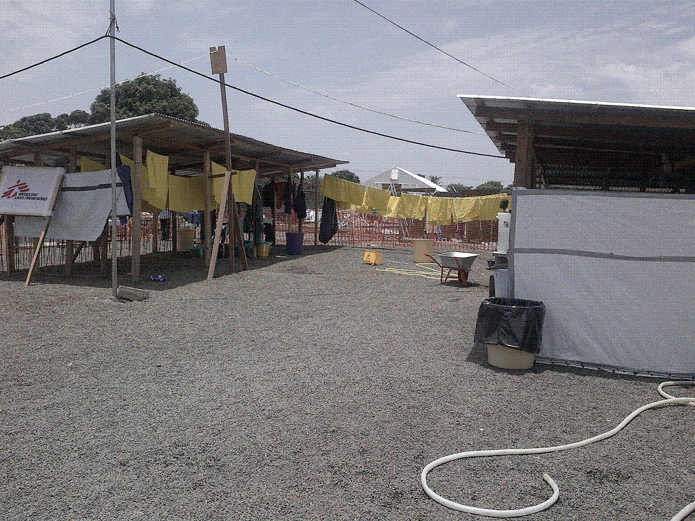 An Ebola treatment unit, its wards laid out under tarpaulins behind orange plastic fencing.