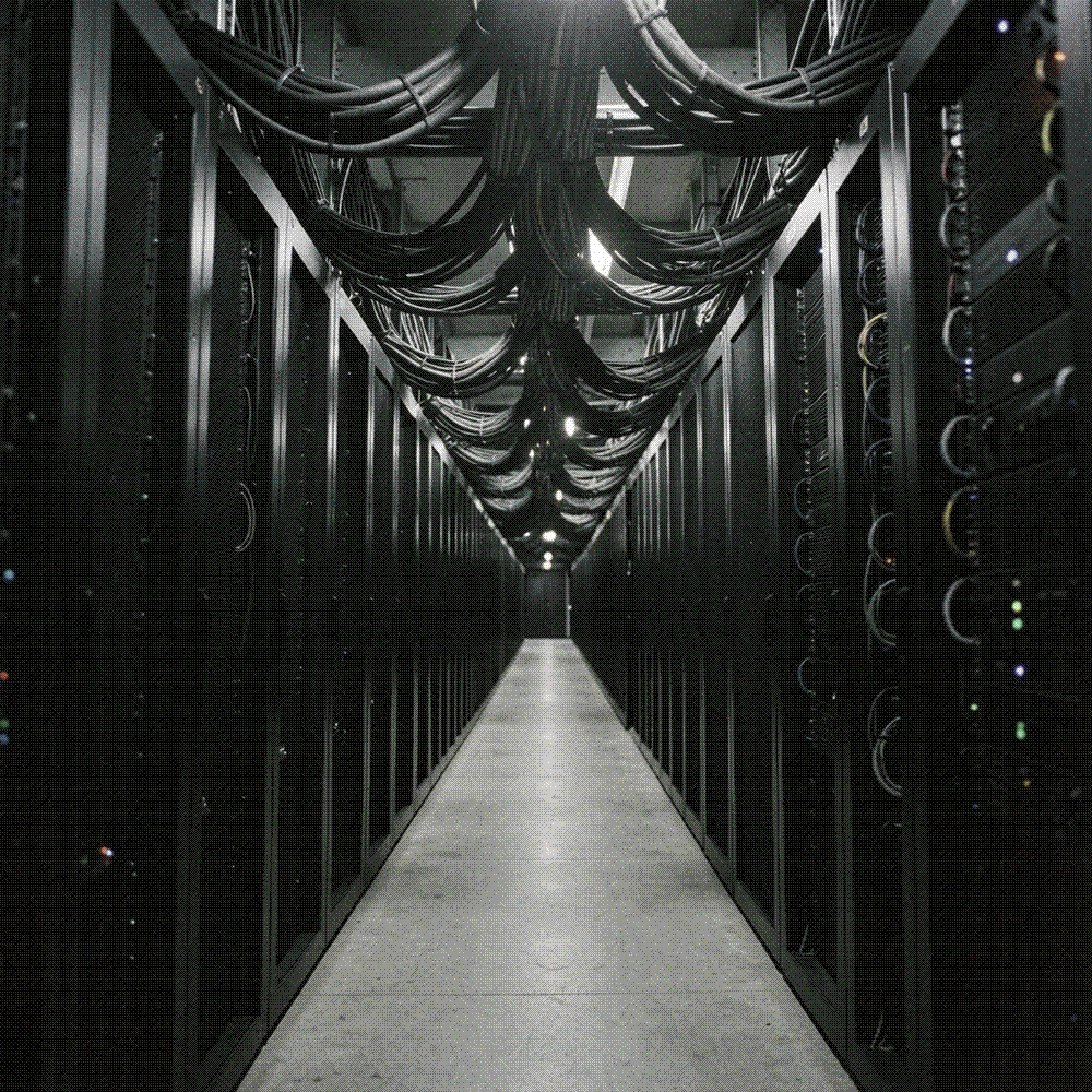 Vast dark hall of server racks receding to a distant vanishing point under a low even glow